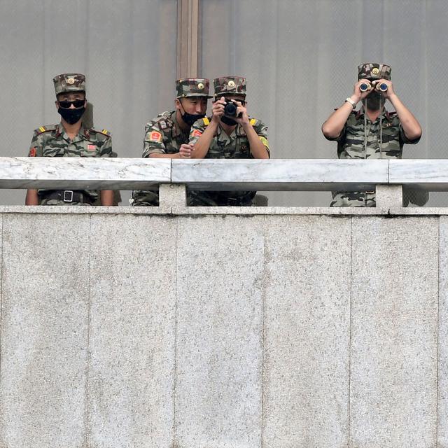 Des soldats nord-coréens surveillent la frontière alors que le ministre sud-coréen de l'Unification, Lee In-young visite la zone de sécurité commune (JSA) sur la zone démilitarisée (DMZ), le 16 septembre 2020. Cette zone minée (on estime le nombre de mines à 1 million) est surveillée par 700'000 soldats nord-coréens et 410'000 soldats sud-coréens aidés par la 2e division d’infanterie des États-Unis, avec qui la Corée du Sud a signé un pacte de sécurité. Il s'agit d'un des rares vestiges de la guerre froide, équivalent à l’ancien rideau de fer. [KOREA POOL/Keystone - Park Tae-Hyun]