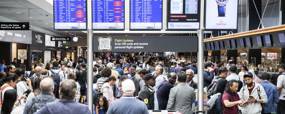 Des passagers photographiés à l'aéroport de Zurich au moment où les vols commencent à reprendre après une panne informatique qui a touché Skyguide. [Keystone - Ennio Leanza]