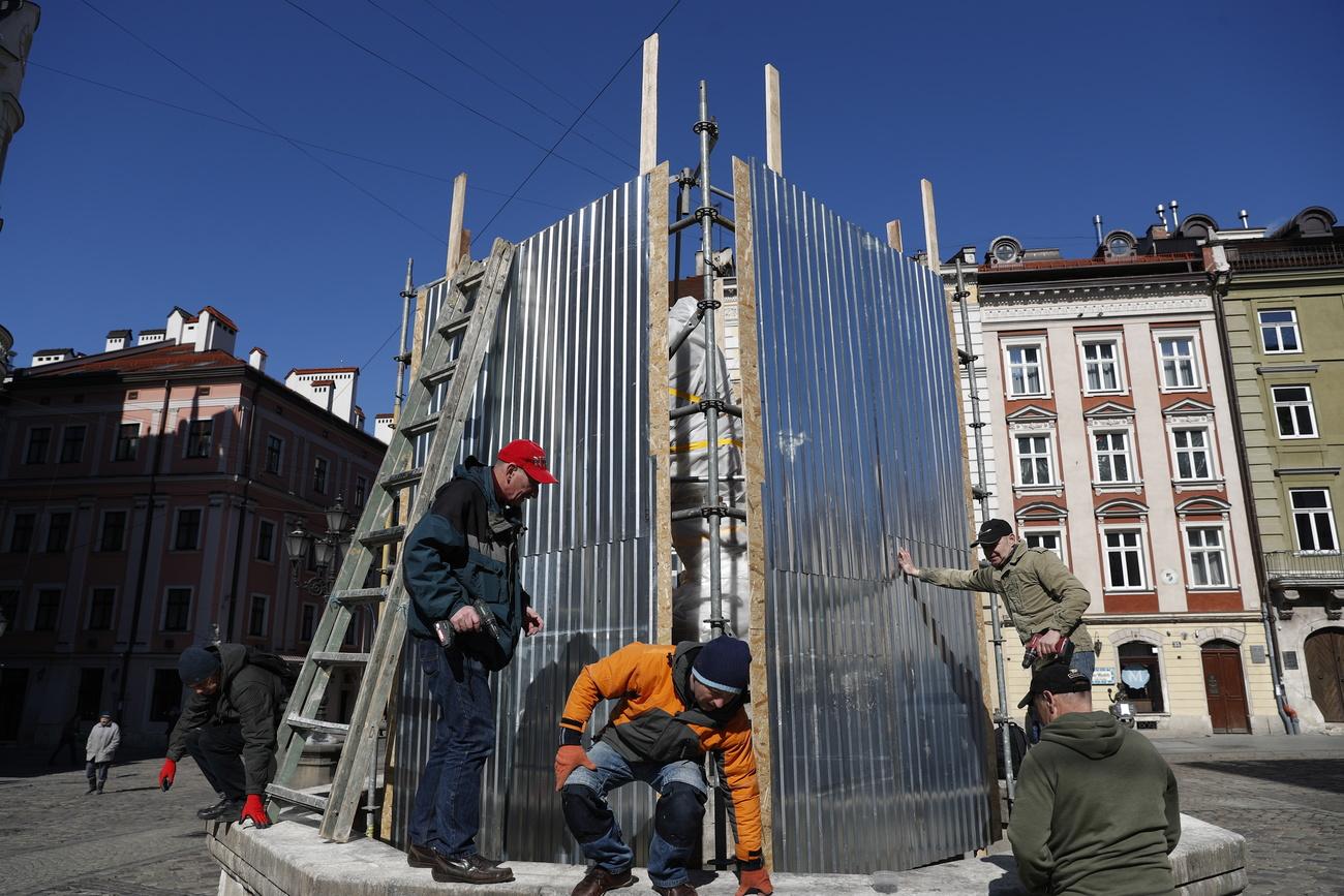 Des employés communaux construisent des protections autour des monuments du centre-ville de Lviv. [AFP - Atef Safadi]