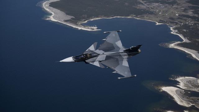 Un avion de chasse suédois Jas 39 Gripen E survole l'île de Gotland dans la mer Baltique, en Suède, le 11 mai 2022. [keystone - Henrik Montgomery]