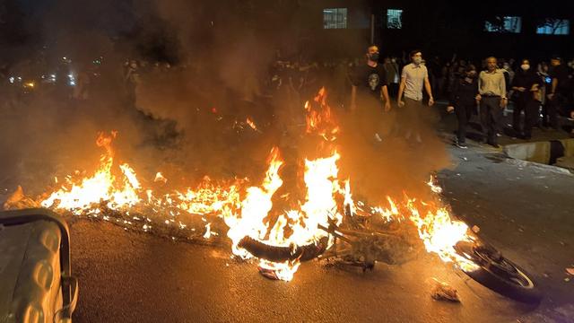 Des manifestants protestent près d'une moto en feu pour Mahsa Amini, une femme tuée après avoir été arrêtée par la "police des mœurs" de la République islamique d'Iran, à Téhéran. [AFP]