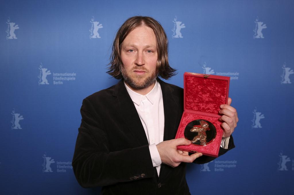 Cyril Schäublin pose après avoir reçu l'Ours d'argent du meilleur réalisateur pour le film "Unrest" lors de la cérémonie de remise des prix de la 72e Berlinale. [AFP - Ronny Hartmann / Pool]