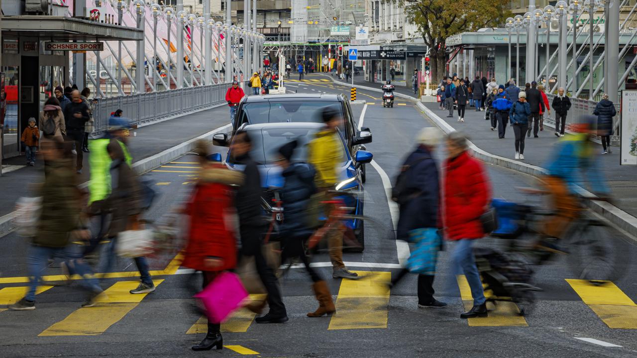 Des piétons, cyclistes et voiture sur le Grand-Pont à Lausanne, rouvert après plus de 9 mois de travaux. [Keystone - Valentin Flauraud]