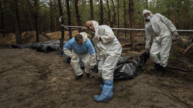 Des corps exhumés d'un cimetière d'Izioum le 23 septembre (image d'illustration). [Keystone/AP Photo - Evgeniy Maloletka]