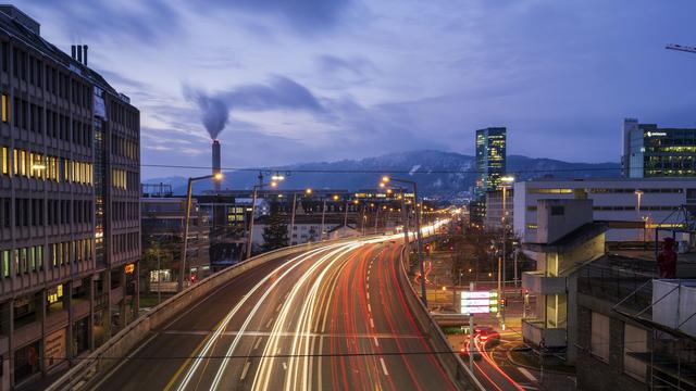 Le trafic sur le Hardbrücke de Zurich à la nuit tombée. [Keystone - Christian Beutler]