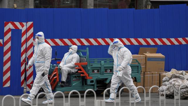 Des agents de sécurité devant un bloc confiné à Pékin. [Keystone/AP Photo - Andy Wong]