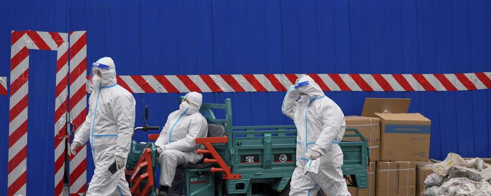 Des agents de sécurité devant un bloc confiné à Pékin. [Keystone/AP Photo - Andy Wong]