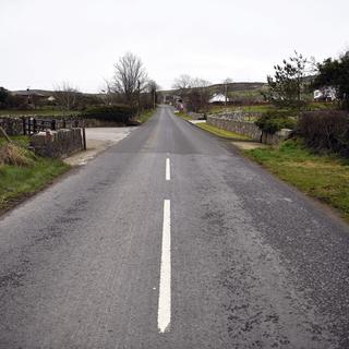 Des marquages routiers et un changement de revêtement routier indiquent la frontière entre la République d'Irlande (à l'arrière) et l'Irlande du Nord (à l'avant) sur une route à l'extérieur de la ville de Newry en Irlande du Nord, en Grande-Bretagne, le 03 mars 2019.