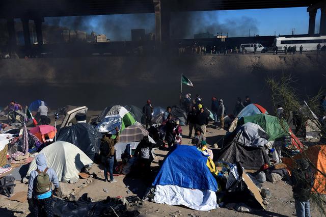 De la fumée s'élève au-dessus d'un campement de migrants près de la frontière américaine, alors que les autorités mexicaines tentent de faire respecter une expulsion, à Ciudad Juarez, au Mexique, le 27 novembre 2022. [KEYSTONE - Luis Torres / EPA]