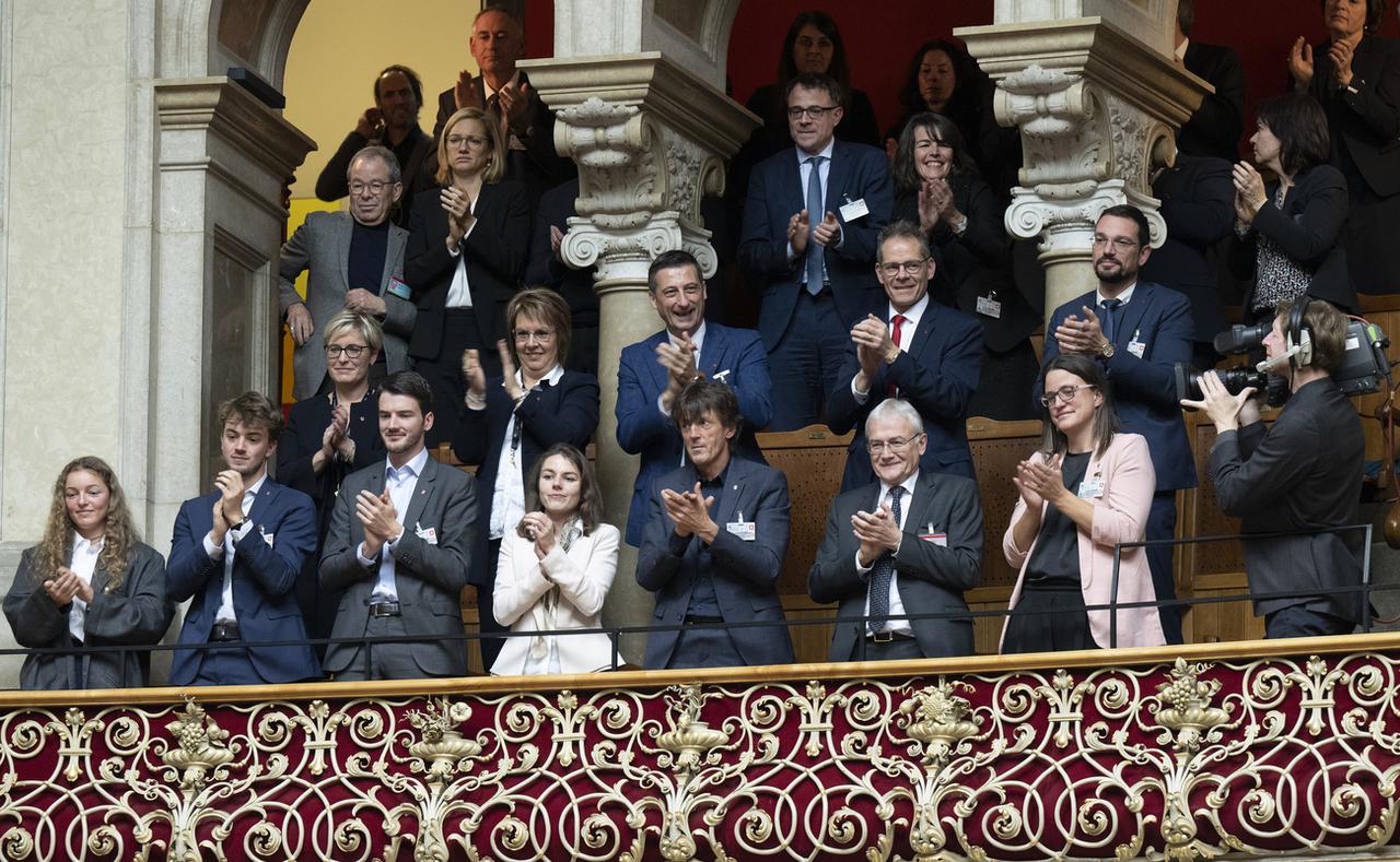 Les proches d'Elisabeth Baume-Schneider (au 1er rang) et les membres du Gouvernement jurassien félicitent la nouvelle conseillère fédérale. [Keystone - Peter Schneider]