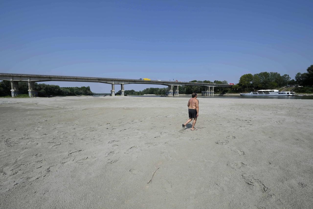 Un homme marche dans le lit du Pô près de Boretto, au nord de Parme, le 15 juin 2022. [Keystone - AP Photo/Luca Bruno]