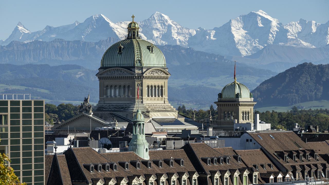 Le Palais fédéral à Berne, photographié avec l'Eiger, le Moench et la Jungfrau. [Keystone - Christian Beutler]