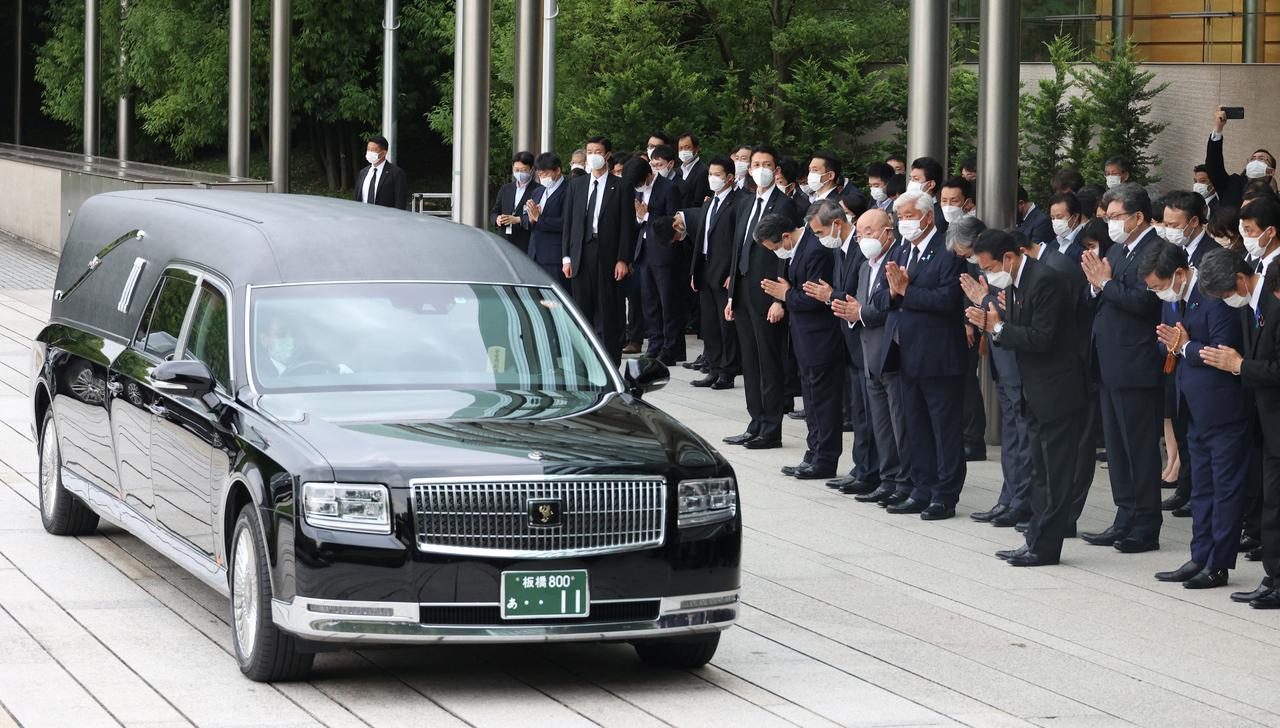 Le Premier ministre japonais Fumio Kishida et des responsables s'inclinent devant le corbillard transportant le corps de l'ancien Premier ministre Shinzo Abe après ses funérailles, dans le quartier de Chiyoda, à Tokyo, le 12 juillet 2022. [AFP - Masanori Genko / The Yomiuri Shimbun]