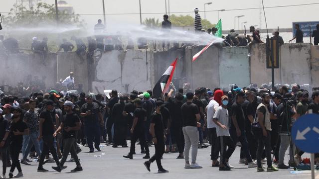 Les forces de sécurité irakiennes interviennent auprès des manifestants partisans du leader chiite Muqtada al-Sadr, qui ont forcé l'entrée de la Zone verte à Bagdad, lors d'une manifestation contre Mohammed al-Sudani, sélectionné comme candidat au poste de Premier ministre du pays. [AFP - Murtadha Al-Sudani / Anadolu Agency]