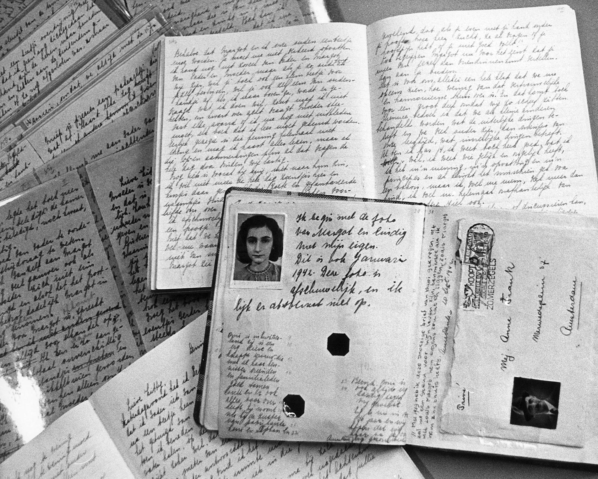 Photo du passeport d'Anne Frank posé sur des cahiers de son journal qu'elle a écrit dans les combes de la maison d'Amsterdam où elle s'était réfugiée avec ses parents à partir de juin 1942. [AFP]