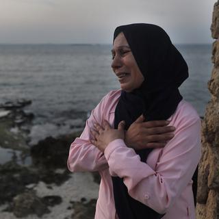 Une femme libanaise s'inquiète de la disparition de son fils en mer lors d'une tentative de rejoindre l'île de Chypre par bateau. [Keystone/AP Photo - Hussein Malla]