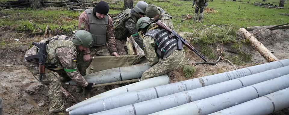 Des soldats ukrainiens collectent des missiles russes après des combats dans le village de Berezivka, dans le sud de l'Ukraine, le 21 avril 2022. [keystone - Efrem Lukatsky]