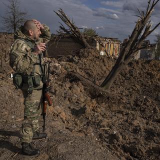 Un Ukrainien observe les décombres après une attaque russe. [Keystone - AP Photo/Evgeniy Maloletka]