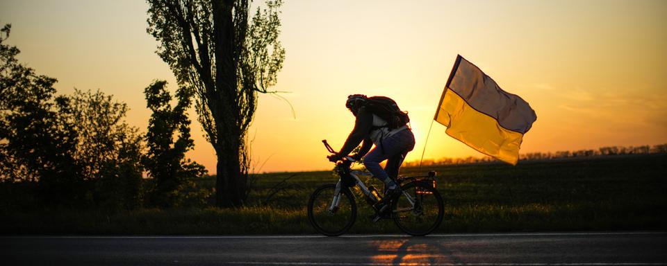 Un vélo orné d'un drapeau ukrainien entre Odessa et Mykolaiv. [Keystone/AP Photo - Francisco Seco]