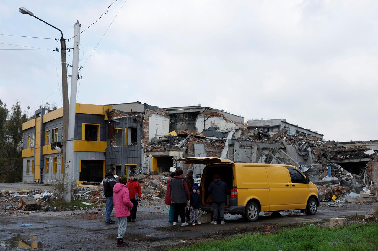 Des civils de Bakhmout sortent de leurs abris pour collecter une aide alimentaire, devant un bâtiment complètement détruit, le 30 octobre 2022. [reuters - Clodagh Kilcoyne]