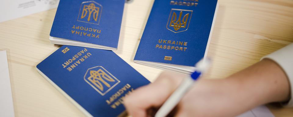 Des passeports ukrainiens sont présentés lors de l'enregistrement au centre d'accueil des réfugiés après l'invasion de l'Ukraine par la Russie à Zurich, en Suisse, le 15 mars 2022. [KEYSTONE - Michael Buholzer]