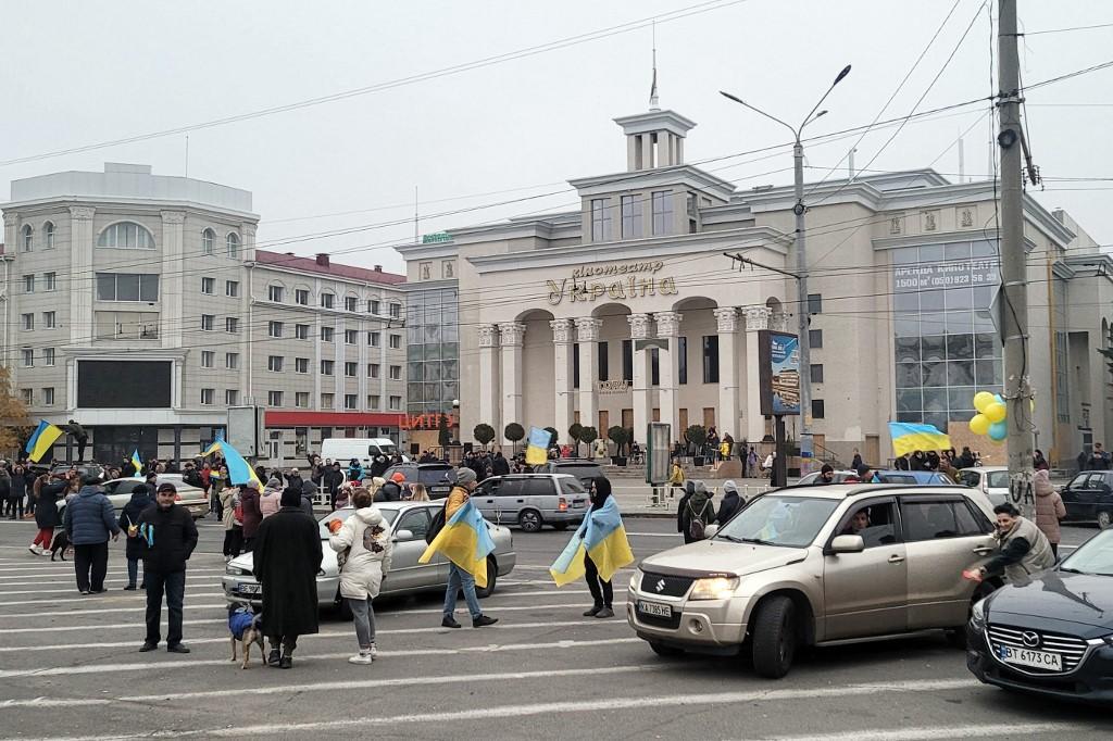 Des habitants et habitantes de Kherson dans les rues de leur ville avec des drapeaux ukrainiens. [AFp - Oleksander Pertsovskyi]