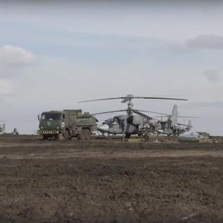 Des hélicoptères et des véhicules de l'armée russe. [Keystone - EPA/Russian Defence Ministry Press Service]