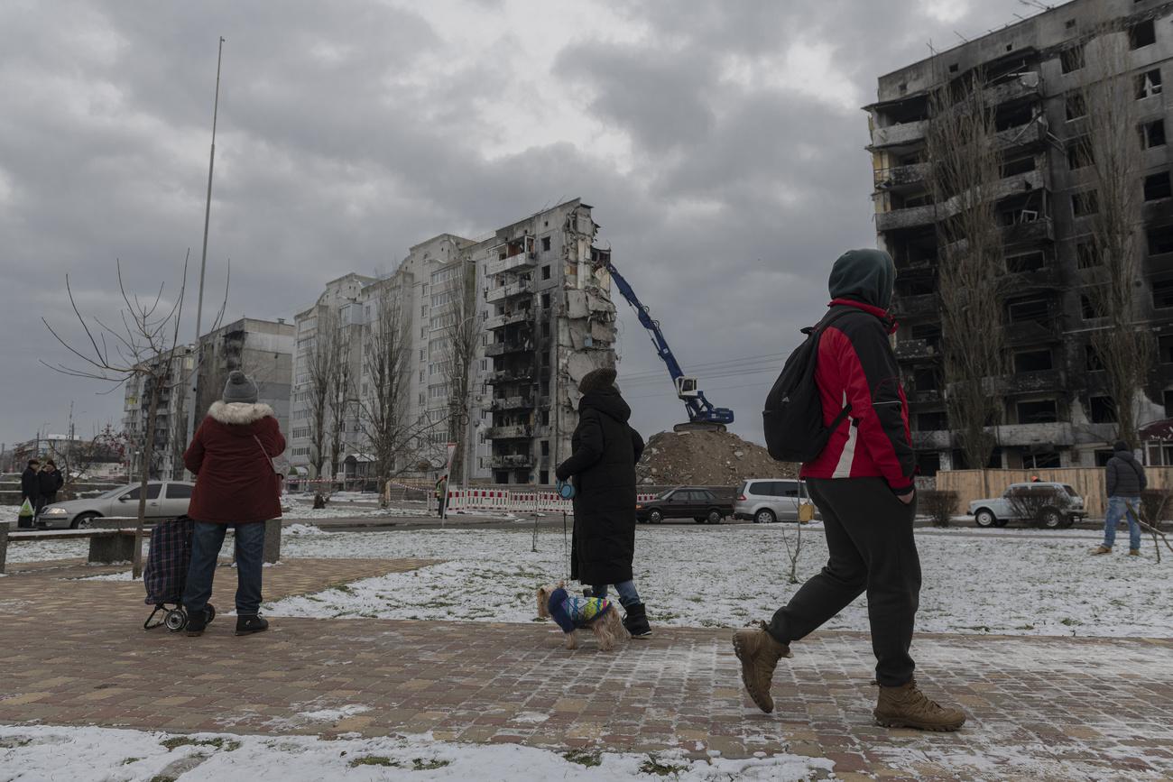 Des habitants devant des immeubles bombardés à Borodyanka, dans la région de Kiev, le 13 décembre 2022. [AP/Keystone - Andrew Kravchenko]