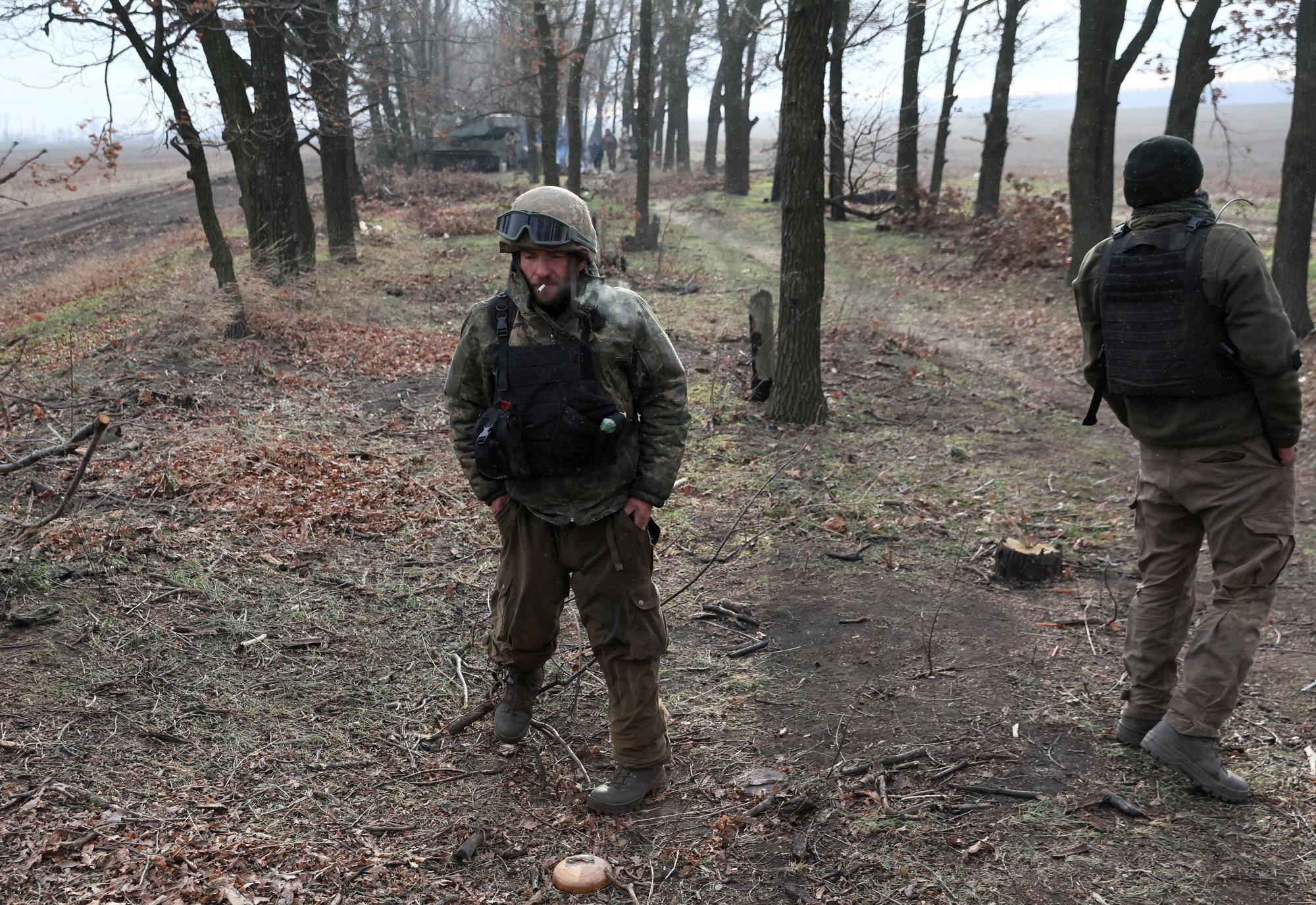 Des soldats ukrainiens tentent de se réchauffer près de Bakhmout, en Ukraine. [Reuters - Leah Millis]