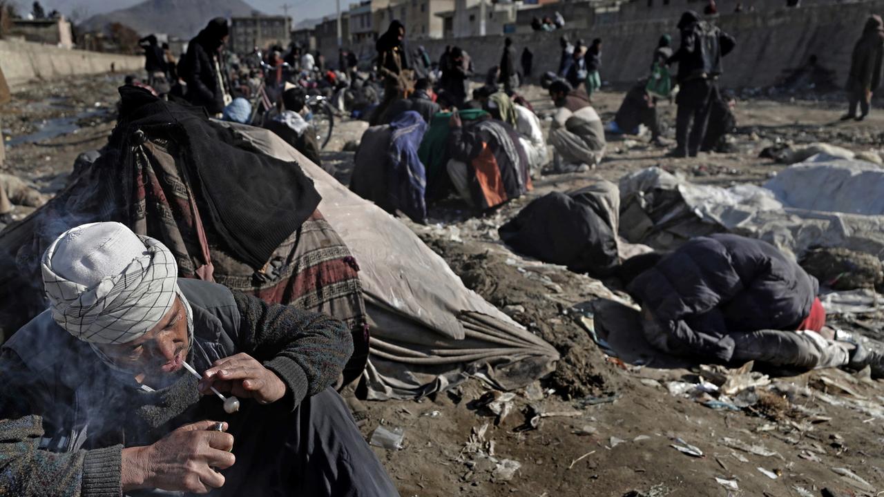 Des Afghans dépendants de l'héroïne et des méthamphétamines se rassemblent pour prendre de la drogue à Kaboul, en Afghanistan, le 14 décembre 2021. [KEYSTONE/EPA - Maxim Shipenkov]