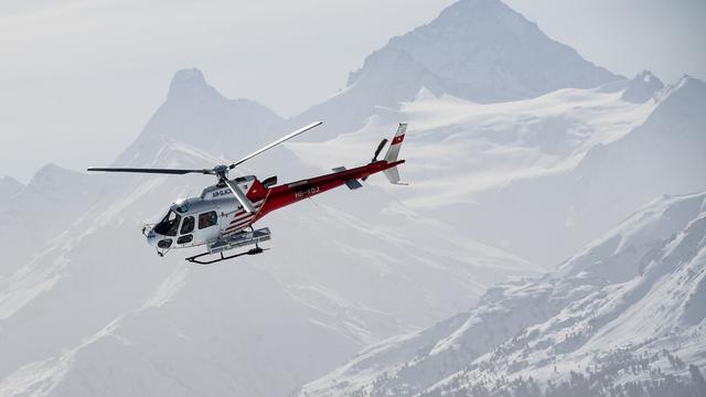 Un hélicoptère de la compagnie Air Glaciers vole au-dessus de Crans-Montana. [Keystone - Jean-Christophe Bott]