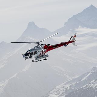 Un hélicoptère de la compagnie Air Glaciers vole au-dessus de Crans-Montana. [Keystone - Jean-Christophe Bott]