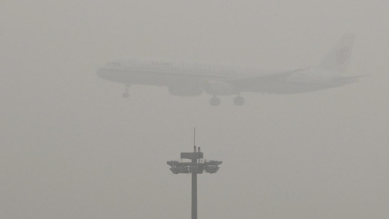Un avion en phase d'atterrissage à Pékin. [Keystone - AP Photo/Andy Wong]