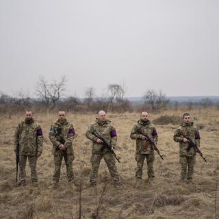Des militaires ukrainiens se préparent à tirer des salves lors des funérailles de leurs camarades Roman Rak et Mykola Mykytiuk à Starychi, dans l'ouest de l'Ukraine, mercredi 16 mars 2022. [AP Photo/KEYSTONE - Bernat Armangue]