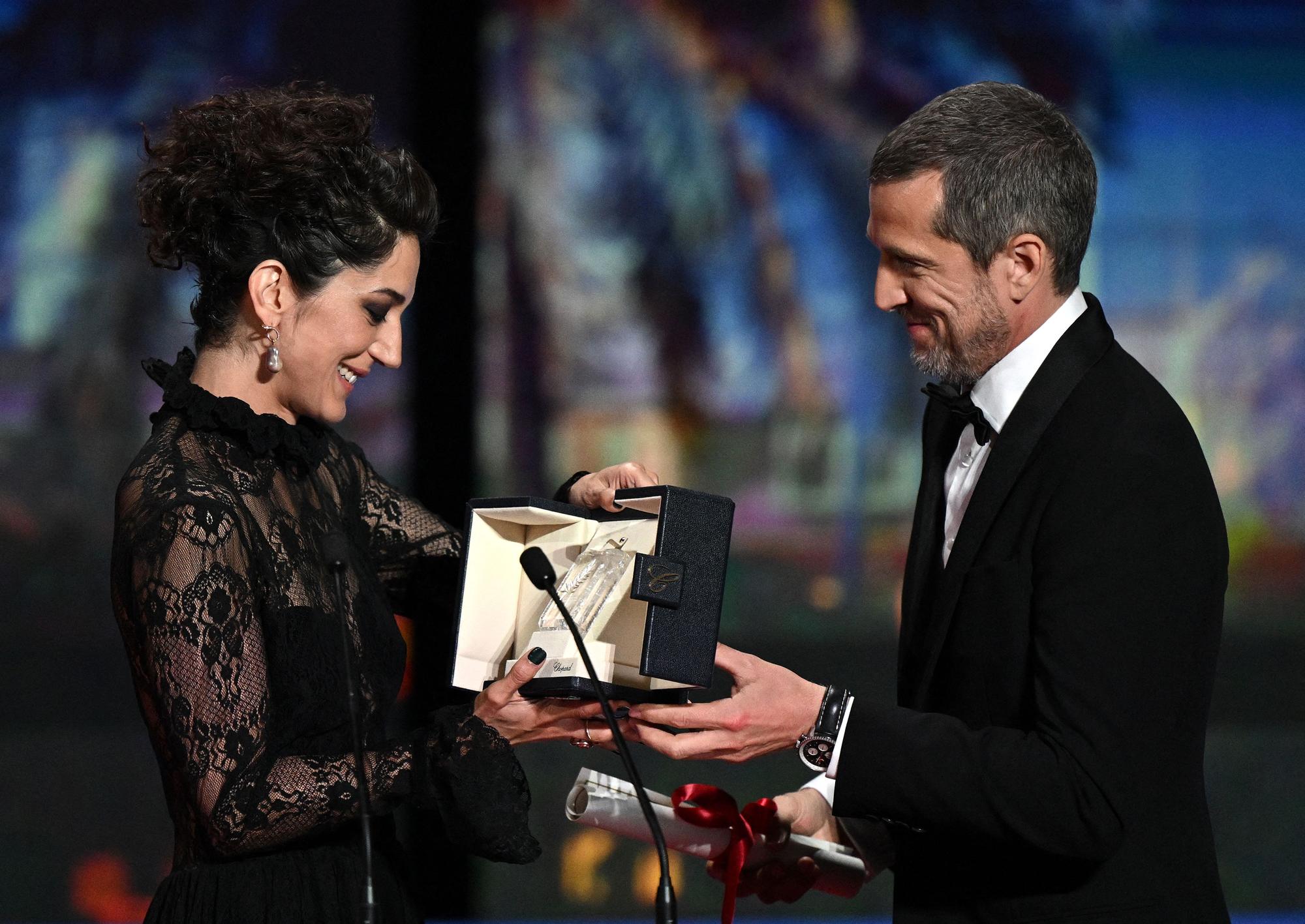L'actrice iranienne Zar Amir-Ebrahimi reçoit le prix de la meilleure actrice des mains de Guillaume Canet pour le film "Holy Spider". [AFP - Christophe Simon]