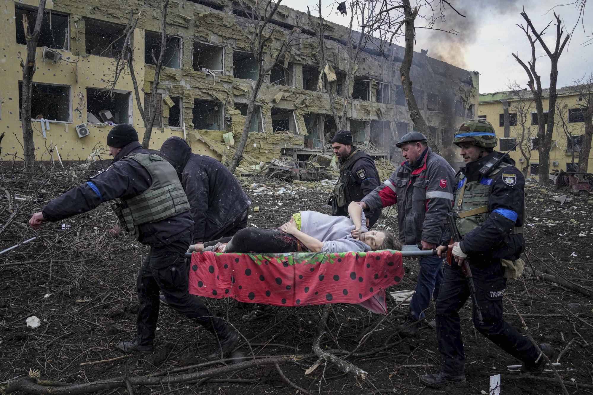 Une femme enceinte blessée après les bombardements russes sur une maternité à Marioupol est transportée sur un brancard. [Keystone - Evgeniy Maloletka / AP Photo]
