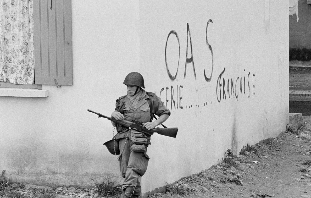 Soldat français devant un graffiti pour l'OAS à Oran en 1962. [Keystone - AP Photo/Horst Faas]