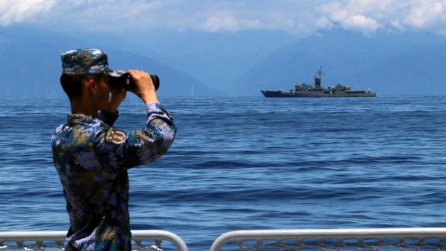 Un soldat regarde à travers des jumelles lors d'exercices militaires de l'Armée populaire de libération chinoise (APL) dans les eaux autour de l'île de Taïwan, le 5 août 2022. [AFP - Lin Jian / Xinhua]