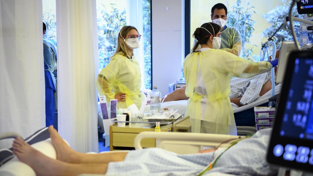 Le personnel soignant de l'hôpital de Neuchâtel s'occuppe d'un patient atteint de Covid-19. [Keystone - Laurent Gillieron]
