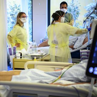 Le personnel soignant de l'hôpital de Neuchâtel s'occuppe d'un patient atteint de Covid-19. [Keystone - Laurent Gillieron]