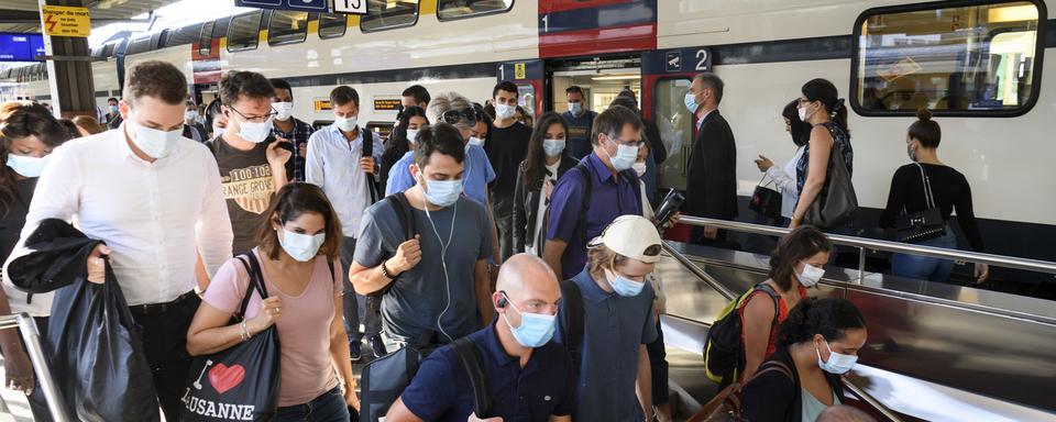 Des voyageurs portant le masque dans la gare de Lausanne. [Keystone - Laurent Gillieron]