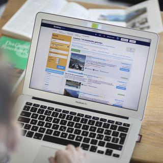 Une personne consulte le site internet de l'agence de voyage en ligne Booking.com sur un ordinateur portable, photographié à Zurich, en Suisse, le 10 mars 2017. [KEYSTONE - Gaetan Bally]