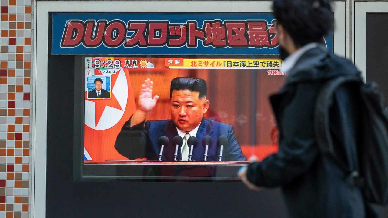 Un passant dans une rue de Tokyo regarde la retransmission de l’allocution du dirigeant nord-coréen Kim Jong-un au sujet des nouveaux tirs de missile. [RICHARD A. BROOKS / AFP]