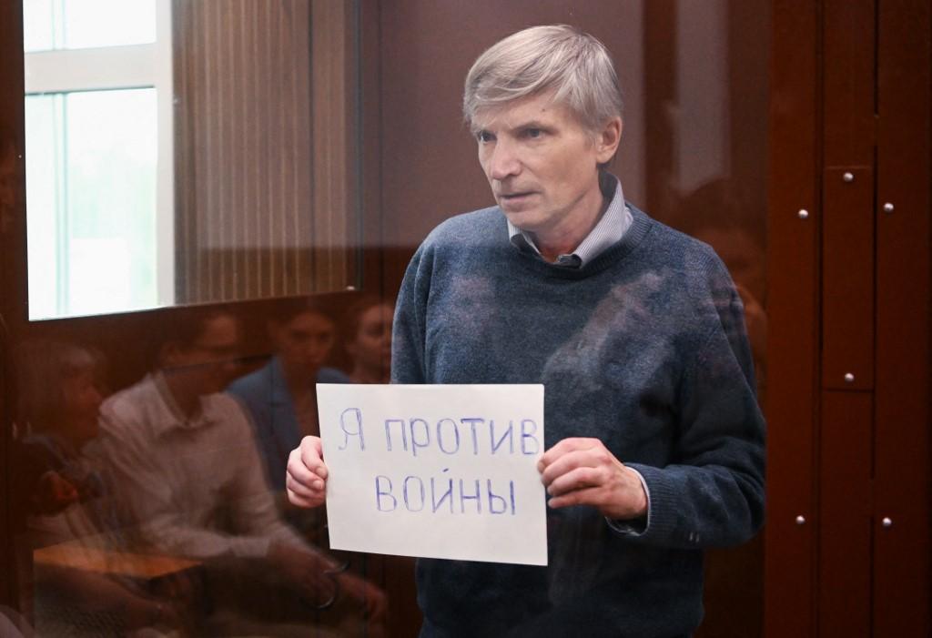Alexeï Gorinov tient une feuille où il est écrit "Non à la guerre". [AFP - Natalia Kolesnikova]