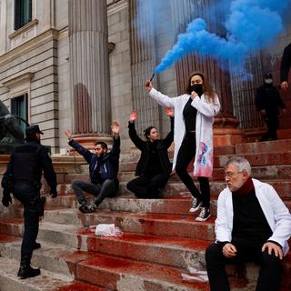 Des militants de l'organisation Scientist Rebellion manifestent après avoir jeté de la peinture rouge devant le parlement espagnol, le 6 avril 2022. [REUTERS - Susana Vera]