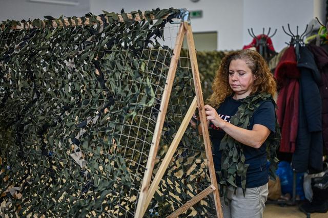 Une réfugiée ukrainienne en Pologne participe à la confection de filets de camouflage à Cracovie. [AFP/Anadolu Agency - Omar Marques]