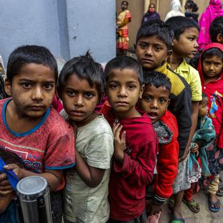 Des enfants sans abri font la queue pour recevoir un repas matinal des Missionnaires de la Charité, l'ordre fondé par Sainte Teresa, à son siège à Kolkata, en Inde, mardi 28 décembre 2021. [AP Photo/Keystone - Bikas Das]