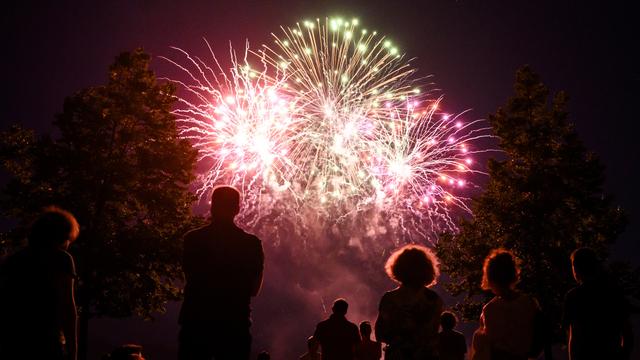 Des personnes regardent le feu d'artifice du premier août, ici au bord du lac Léman à Ouchy (image d'illustration). [Keystone - Jean-Christophe Bott]