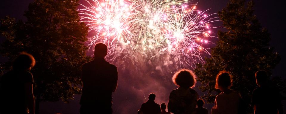 Des personnes regardent le feu d'artifice du premier août, ici au bord du lac Léman à Ouchy (image d'illustration). [Keystone - Jean-Christophe Bott]