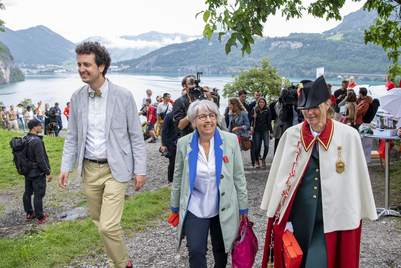 La conseillère fédérale Elisabeth Baume-Schneider, le président de la SSUP Nicola Forster (à gauche) et l'huissière Lilian Halter, lors de la Fête nationale sur le Grütli, placée sous le signe de la jeunesse suisse, le 1er août 2023. [KEYSTONE - URS FLUEELER]